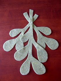 three pieces of felt sitting on top of a wooden table next to a red surface