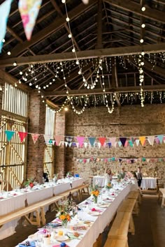 a long table is set up with place settings and bunting for the guests to eat