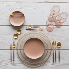 the table is set with gold plates and utensils