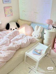 a child's bedroom with pink and white bedding, stuffed animals, and toys