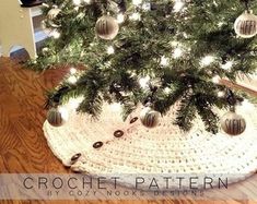 a crocheted christmas tree skirt with baubles and lights on the bottom