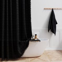 a bathtub with a black shower curtain next to it