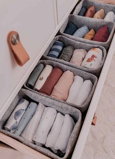 an open drawer with several pairs of slippers in it