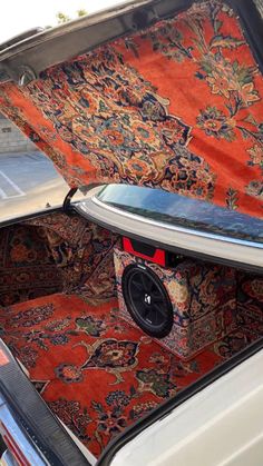 the trunk of a car with an area rug on it