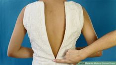 the back of a woman's wedding dress with her hands on her hips