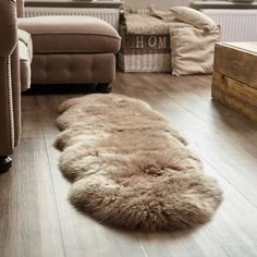 a living room filled with furniture and a rug on top of a hard wood floor