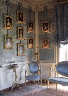 an ornately decorated room with blue chairs and pictures on the wall