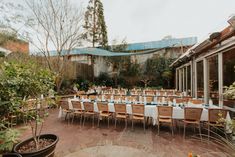 an outdoor dining area with tables and chairs set up for a formal dinner or party