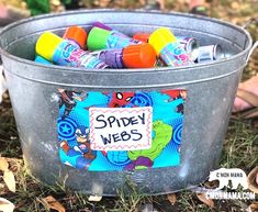 a bucket filled with lots of toys and writing on it that says spider webs