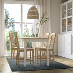 a dining room table with chairs and a rug