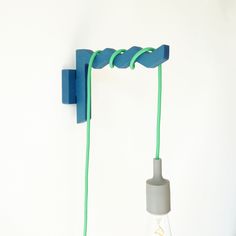 the light bulb is plugged in and attached to the wall by two green cords