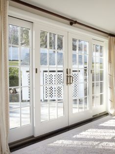 an empty room with french doors and windows