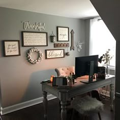 a desk with a computer on top of it in front of a window and stairs