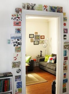 an open door leading to a living room with pictures on the wall and a couch