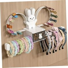 there is a rack with many hair clips on it and a bunny head hanging from the wall