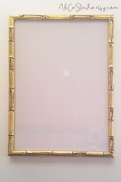 a gold frame is hanging on the wall