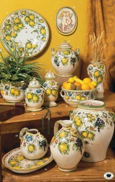 a table topped with vases filled with lemons next to other containers and dishes