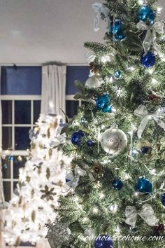 a white christmas tree with blue and silver ornaments