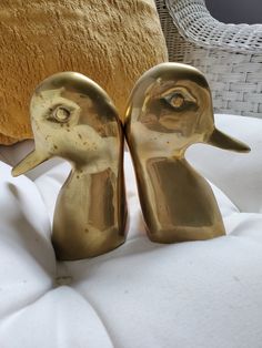 two golden ducks sitting on top of a bed