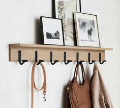 the coat rack is holding two purses and three hats on it's hooks