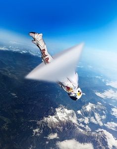 an airplane flying in the sky with mountains and clouds behind it, as seen from above