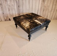 the footstool is made from an old bench with cow hide on it's back