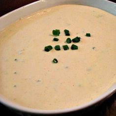 a white bowl filled with soup on top of a wooden table