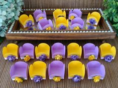 purple and yellow chairs with flowers on them sitting in front of a tray full of plates