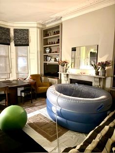 an inflatable pool sits on the floor next to a living room with furniture