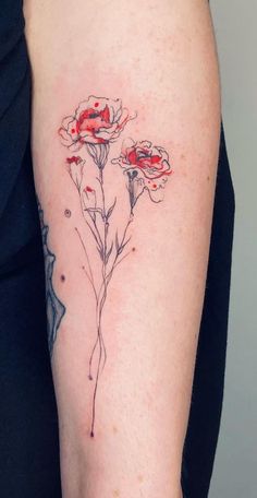 a close up of a person's arm with red flowers on the left side