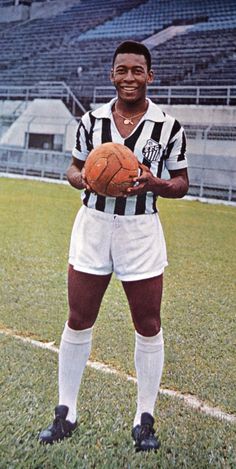 a man holding a soccer ball on top of a field