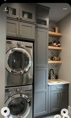 a washer and dryer in a small room with shelves on the wall behind them