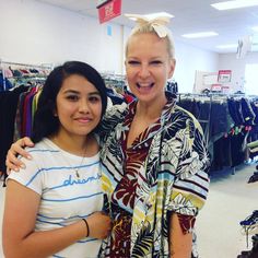 two women standing next to each other in a clothing store