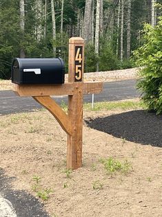 a mailbox with the number forty five on it in front of a wooded area