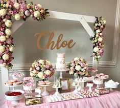 a table topped with lots of cakes and cupcakes next to a sign that says gloe