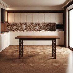 an empty kitchen with wood flooring and white cupboards on either side of the table