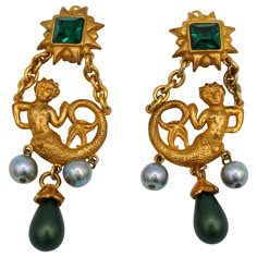 YVES SAINT LAURENT vintage rare gold tone dangling earrings (clip on) featuring a mermaid topped by a radiant sun embellished with a large emerald colour crystal, glass faux pearl (iridescent grey) and drop (matte olive green). Embossed YSL Made in France. Indicative measurements : max. height approx. 9.2 cm (3.62 inches) / max. width approx. 3.3 cm (1.30 inches). Material : Gold tone metal hardware / Crystal / Glass. Weight per earring : approx. 23 grams. Come with a YVES SAINT LAURENT 5 avenue Yves Saint Laurent Jewelry, 1stdibs Jewelry, Ysl Earrings, Emerald Colour, Ysl Jewelry, Ysl Vintage, Saint Laurent Vintage, Vintage Gold Earrings, Vintage Earring