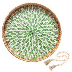 a green and white decorative plate with tassels