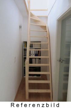 there is a wooden staircase going up to the top floor in this room with bookshelves