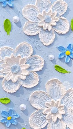 blue and white paper flowers on a light blue background with green leaves in the center