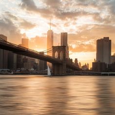 the sun is setting over the brooklyn bridge