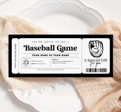 a baseball game ticket sitting on top of a white plate next to a pink scarf