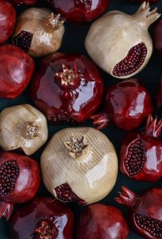 many pomegranates are arranged in rows on a black surface with red and yellow accents