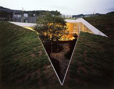 an upside down view of a building with grass on the ground and trees in front