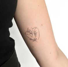 a woman's arm with a small tattoo on the left side of her arm