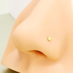 a small gold star stud on top of a white mannequin's head