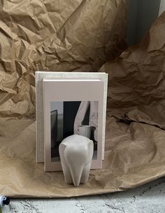 an open book with a white vase sitting on top of it