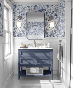 a blue and white bathroom with floral wallpaper on the walls, two sinks and a large mirror