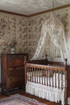 an old fashioned crib in a room with floral wallpaper and white canopy over it