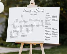 a white board with a crossword puzzle on it in front of some grass and trees